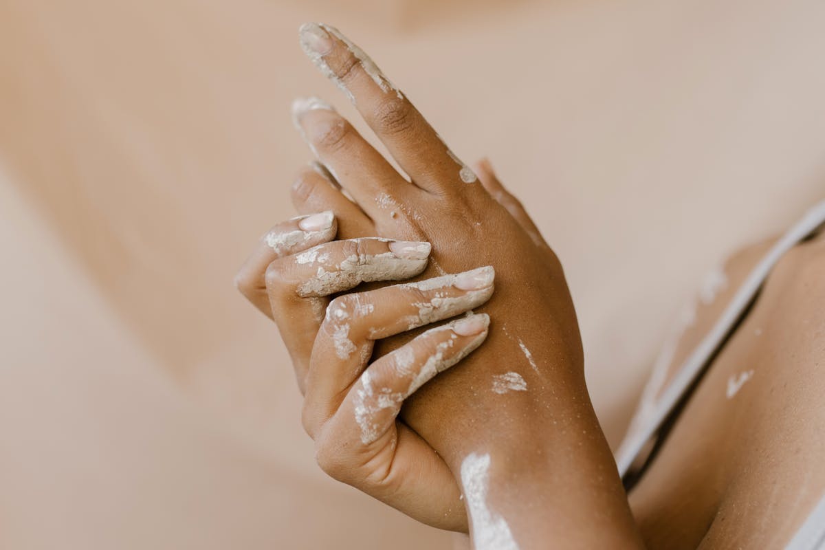 Detailed shot of hands with dried clay, symbolizing artistry and craftsmanship.
