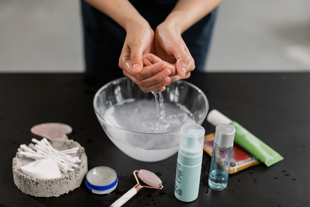 Hands washing with skincare products, emphasizing a thorough beauty regimen.