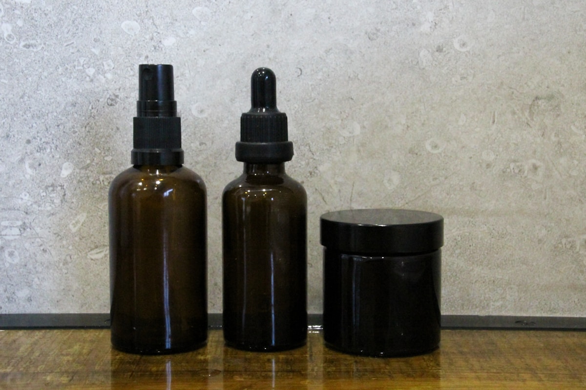 Photo by Denley Photography a couple of brown bottles sitting on top of a wooden table